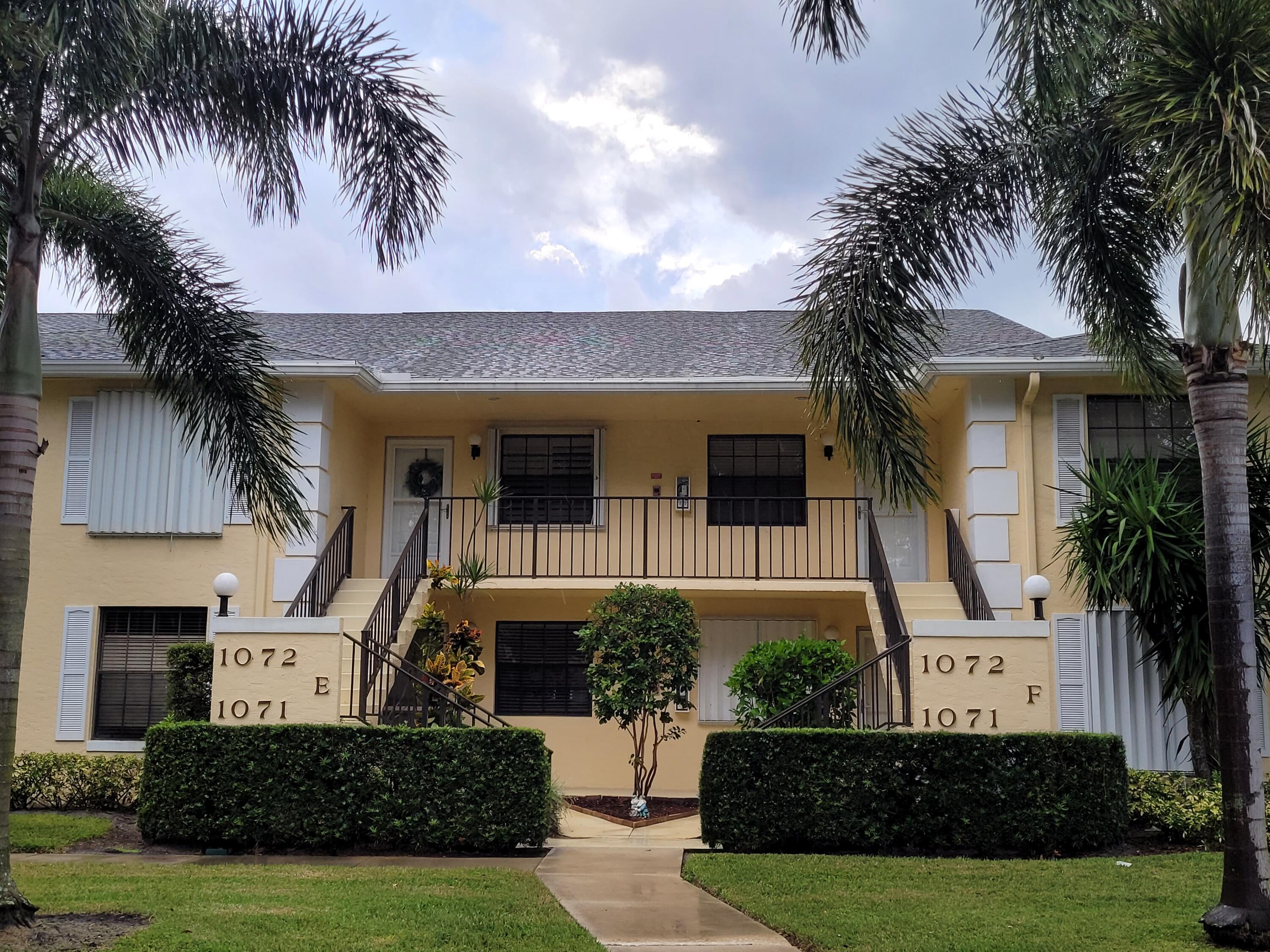 a front view of a house with a yard and potted plants