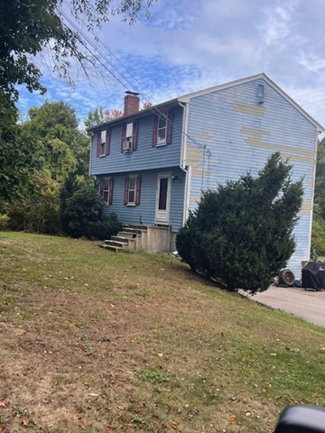 a brick building with a yard and a large tree