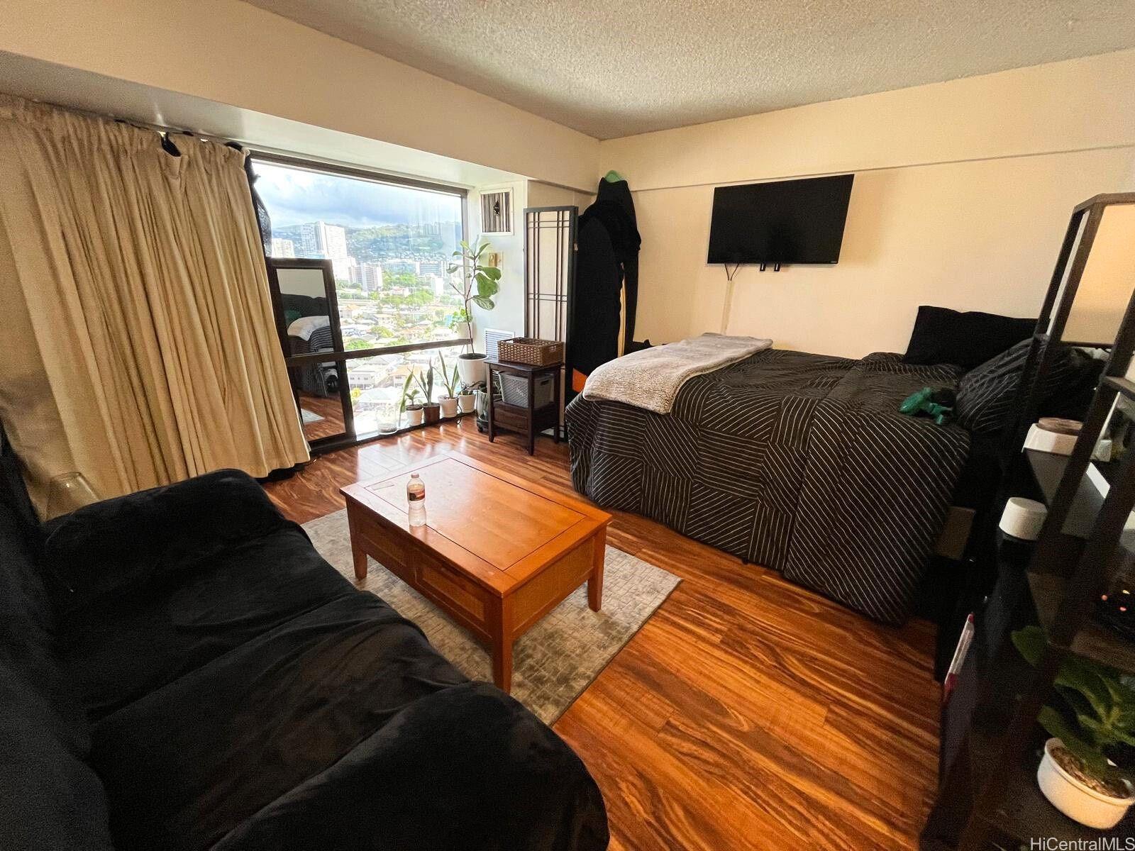 a bedroom with a bed window and flat screen tv