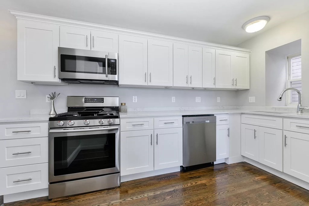 a kitchen with white cabinets and stainless steel appliances