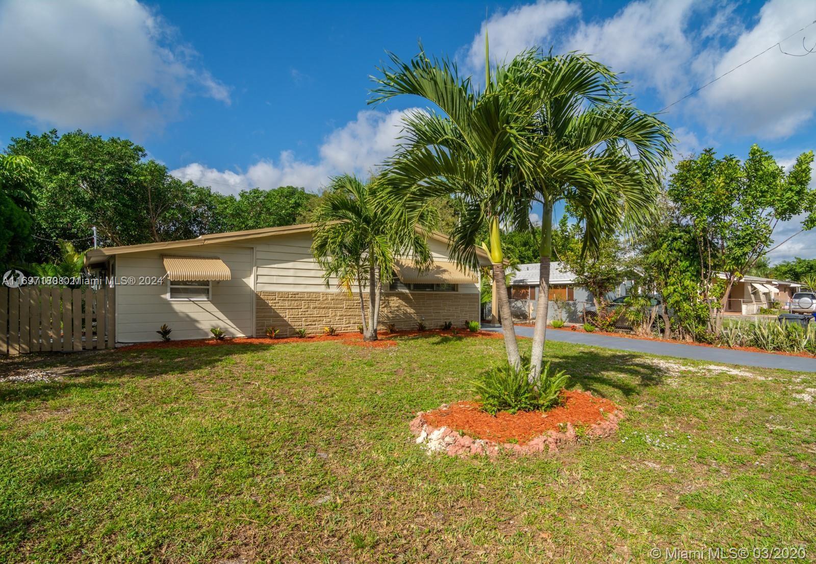 a backyard of a house with plants and tree