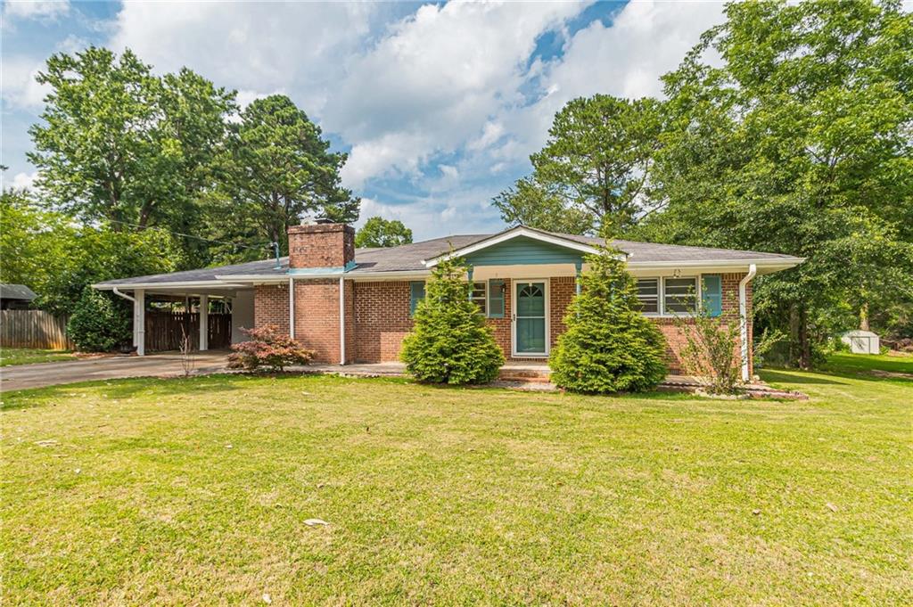 a view of a house with a patio and a yard