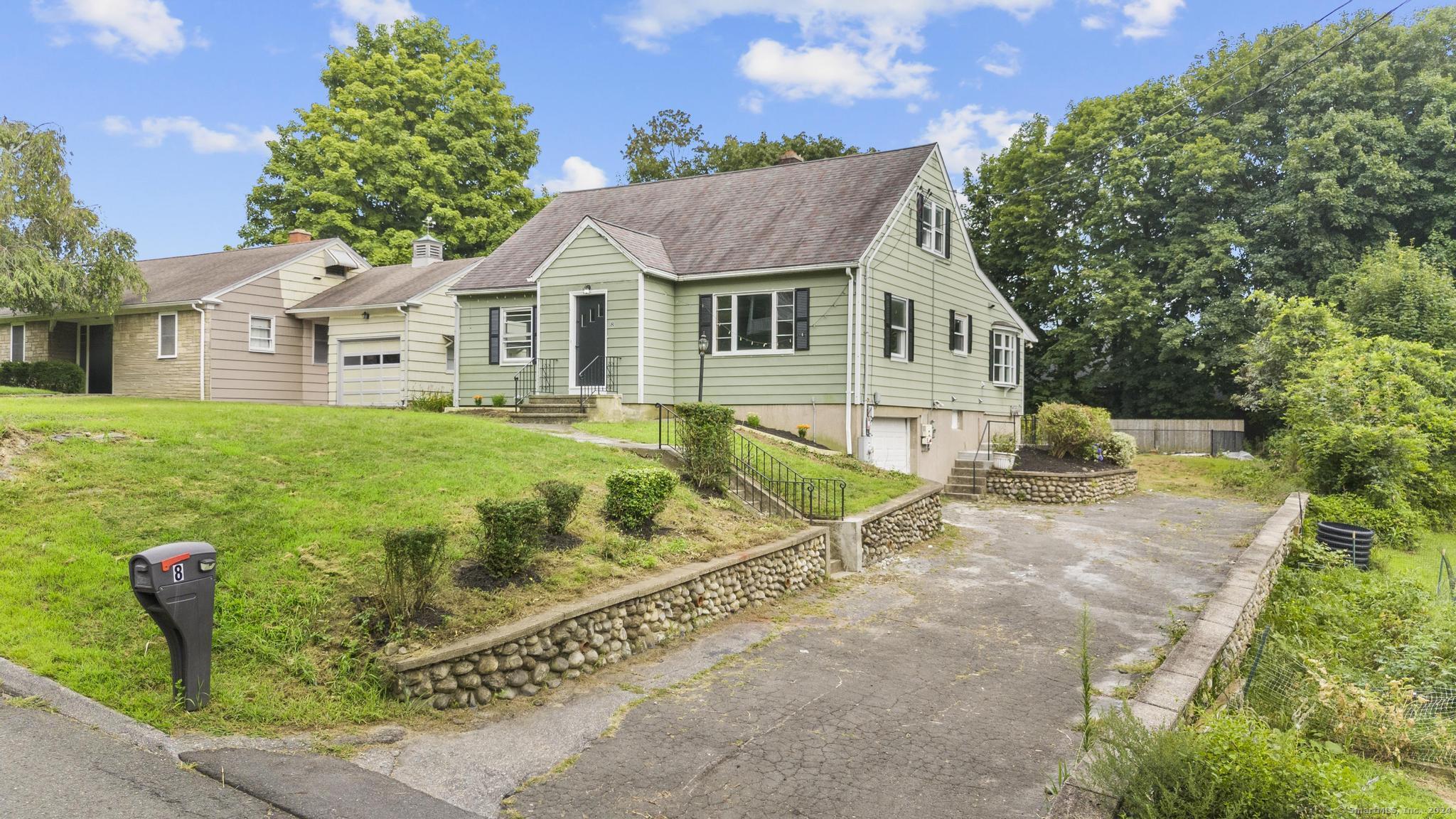 a front view of a house with a yard and trees