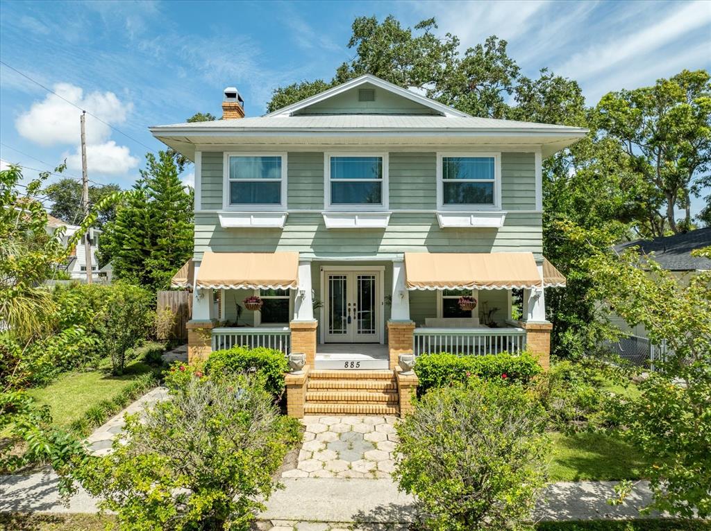 a front view of a house with a yard and potted plants