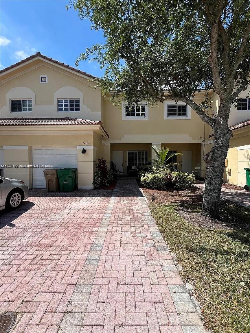 a front view of a house with a yard and a garage