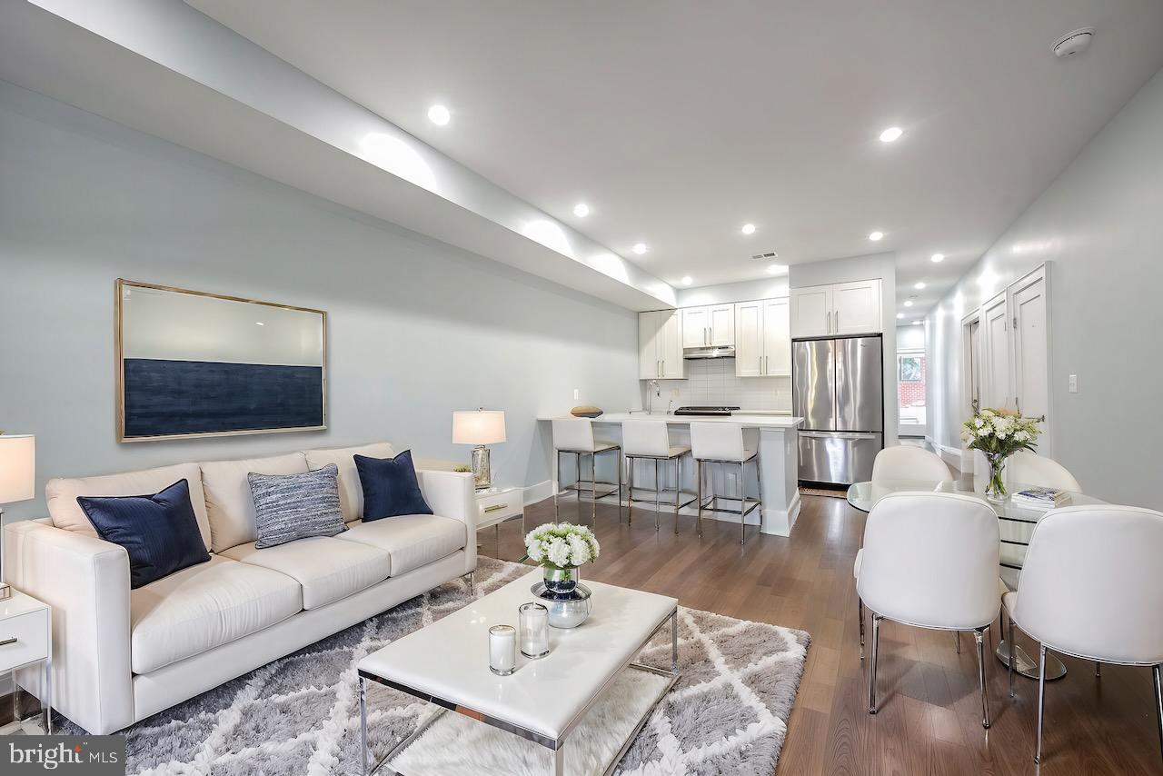 a living room with furniture kitchen view and a table