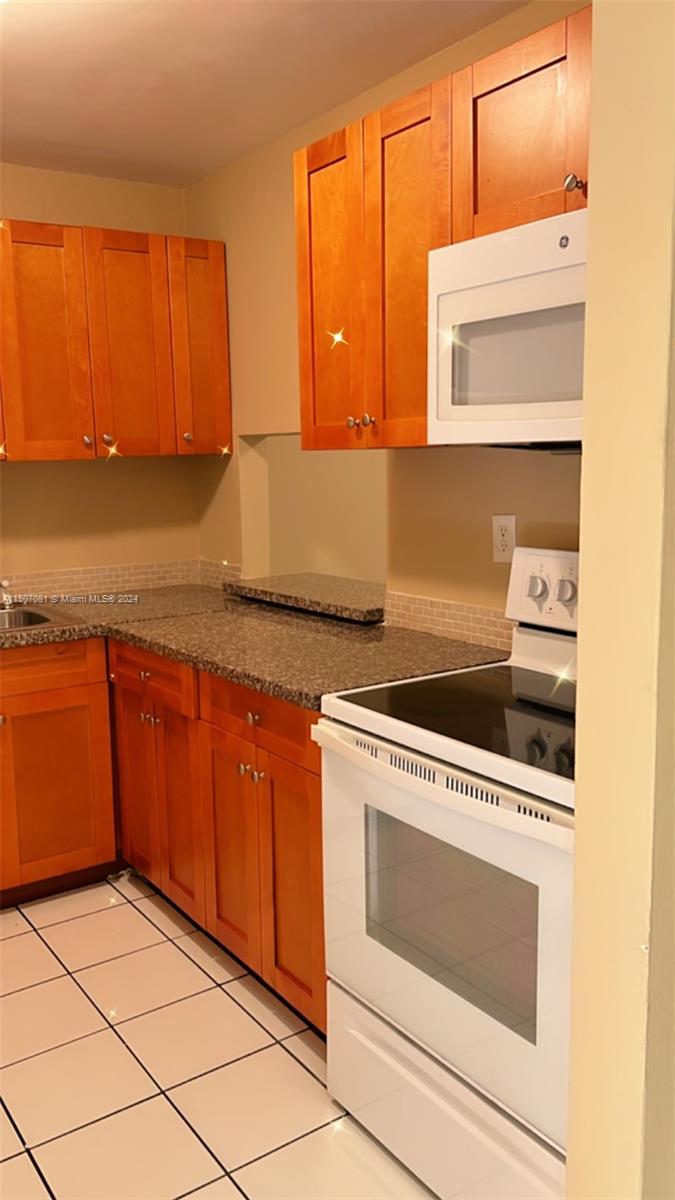 a kitchen with granite countertop cabinets and white appliances