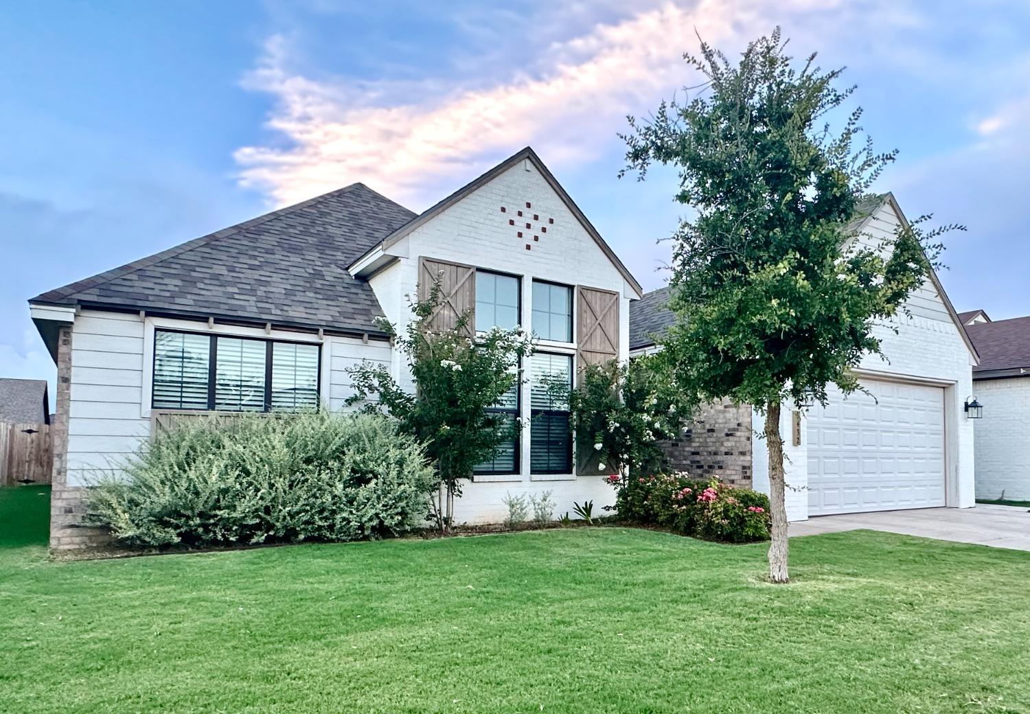 a front view of a house with a garden and yard