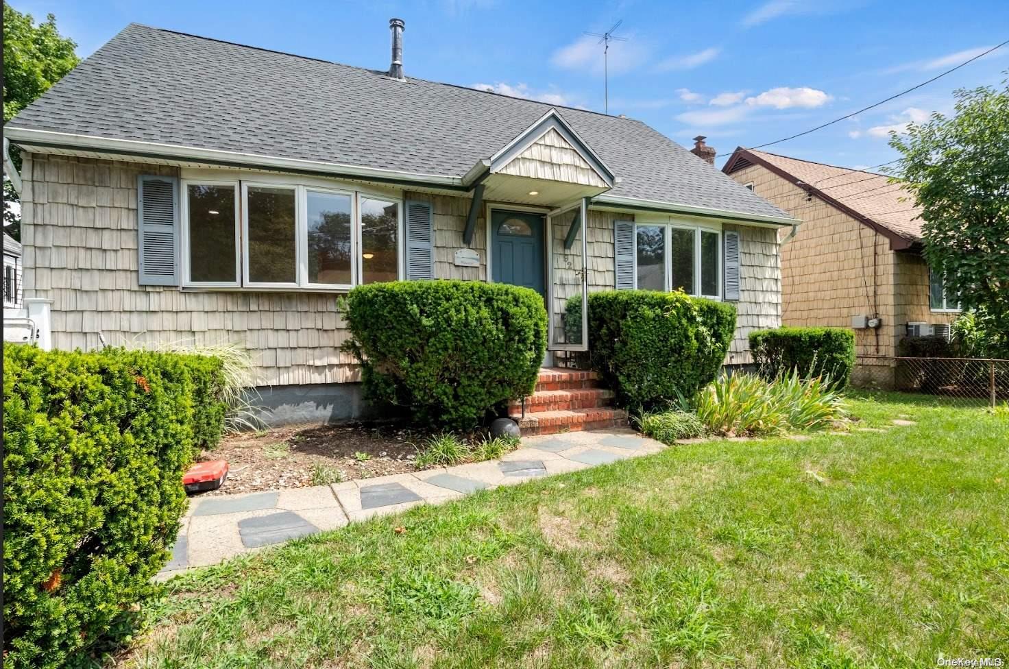 a front view of house with yard and outdoor seating