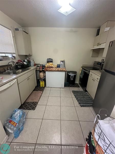 a kitchen with a sink a stove and cabinets