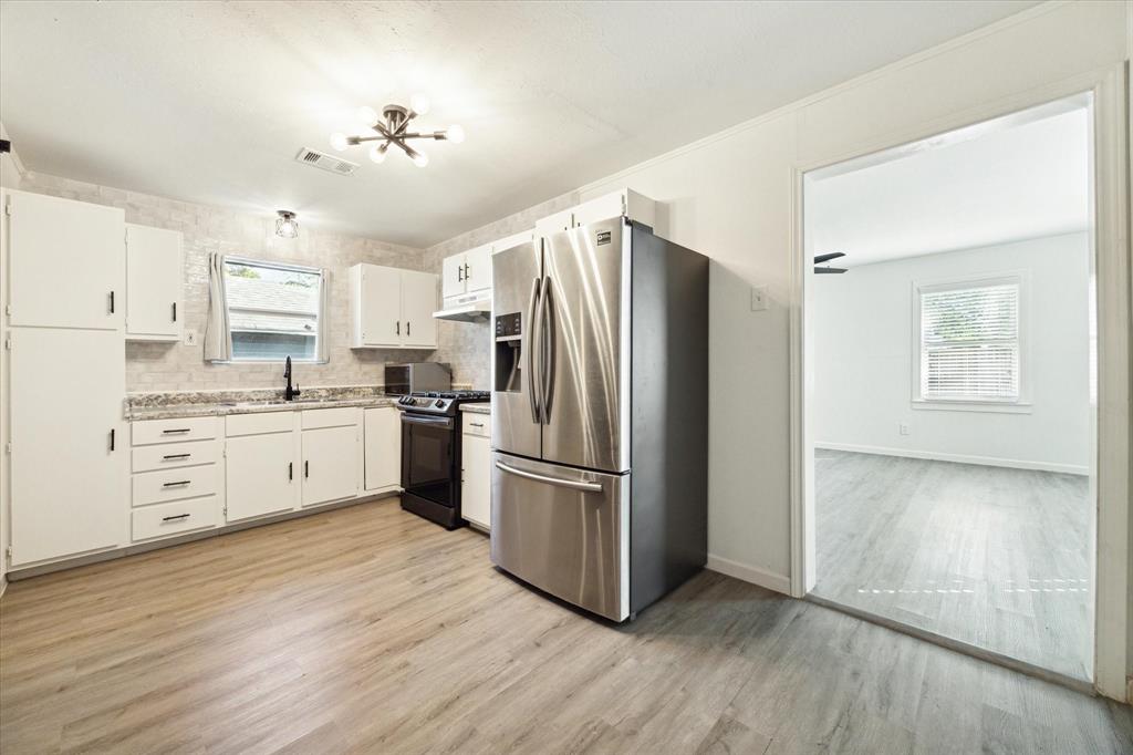 a kitchen with stainless steel appliances a refrigerator sink and cabinets