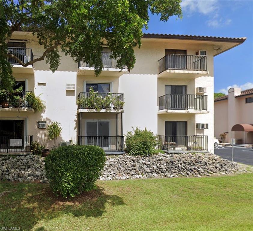 Back of property featuring a lawn and a balcony