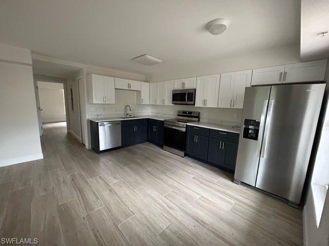 a kitchen with stainless steel appliances a refrigerator sink and microwave