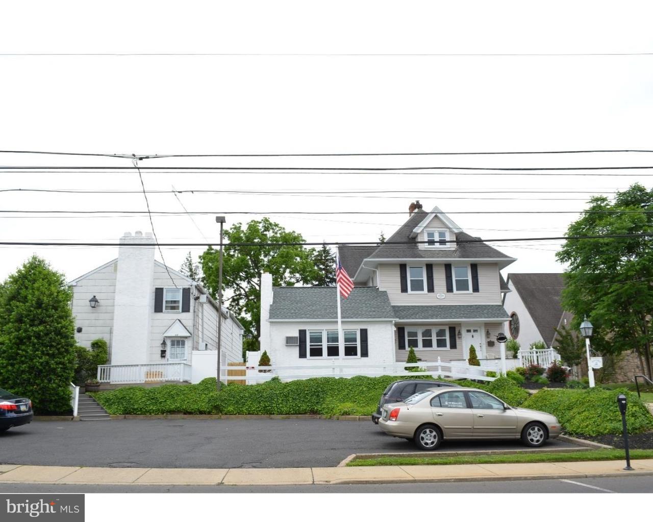 a view of a white house next to a yard