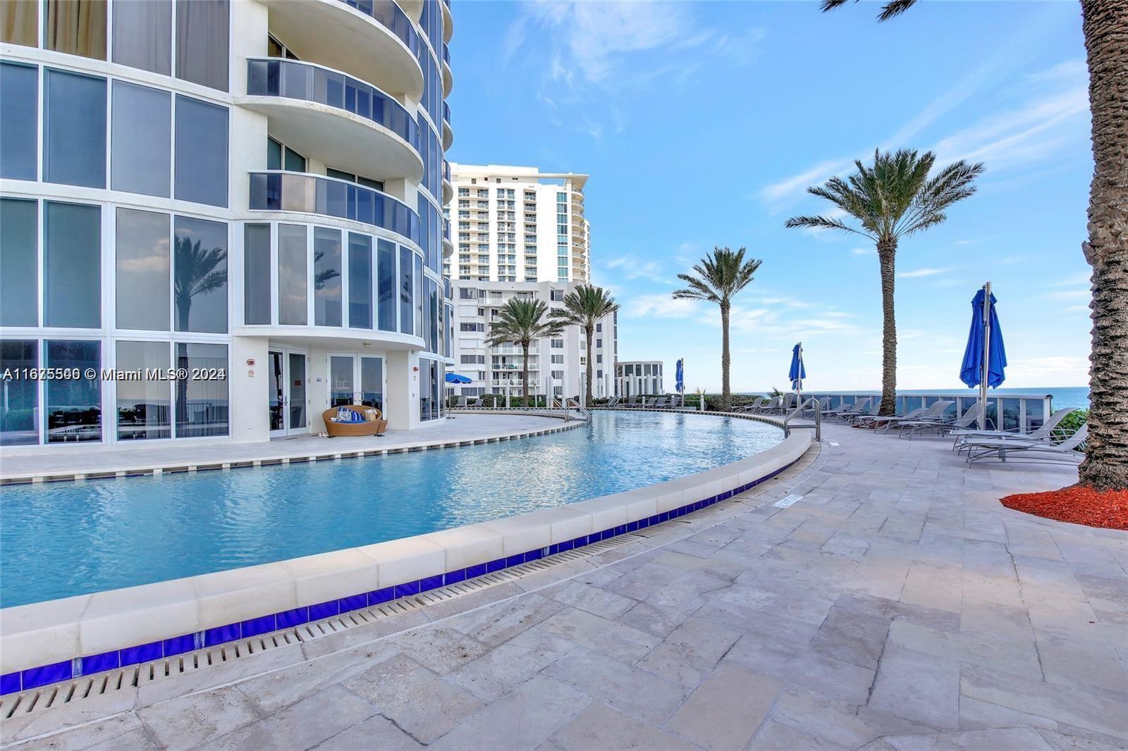 a view of swimming pool with outdoor seating and a palm tree