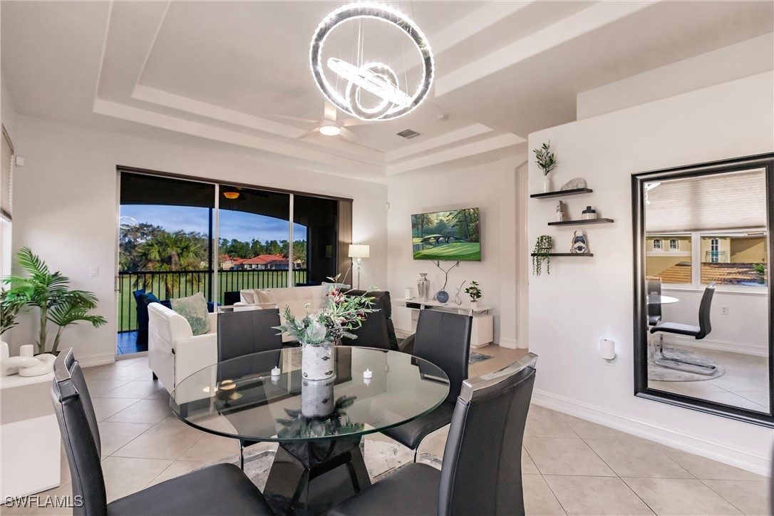 a dining room with furniture a large window and a chandelier