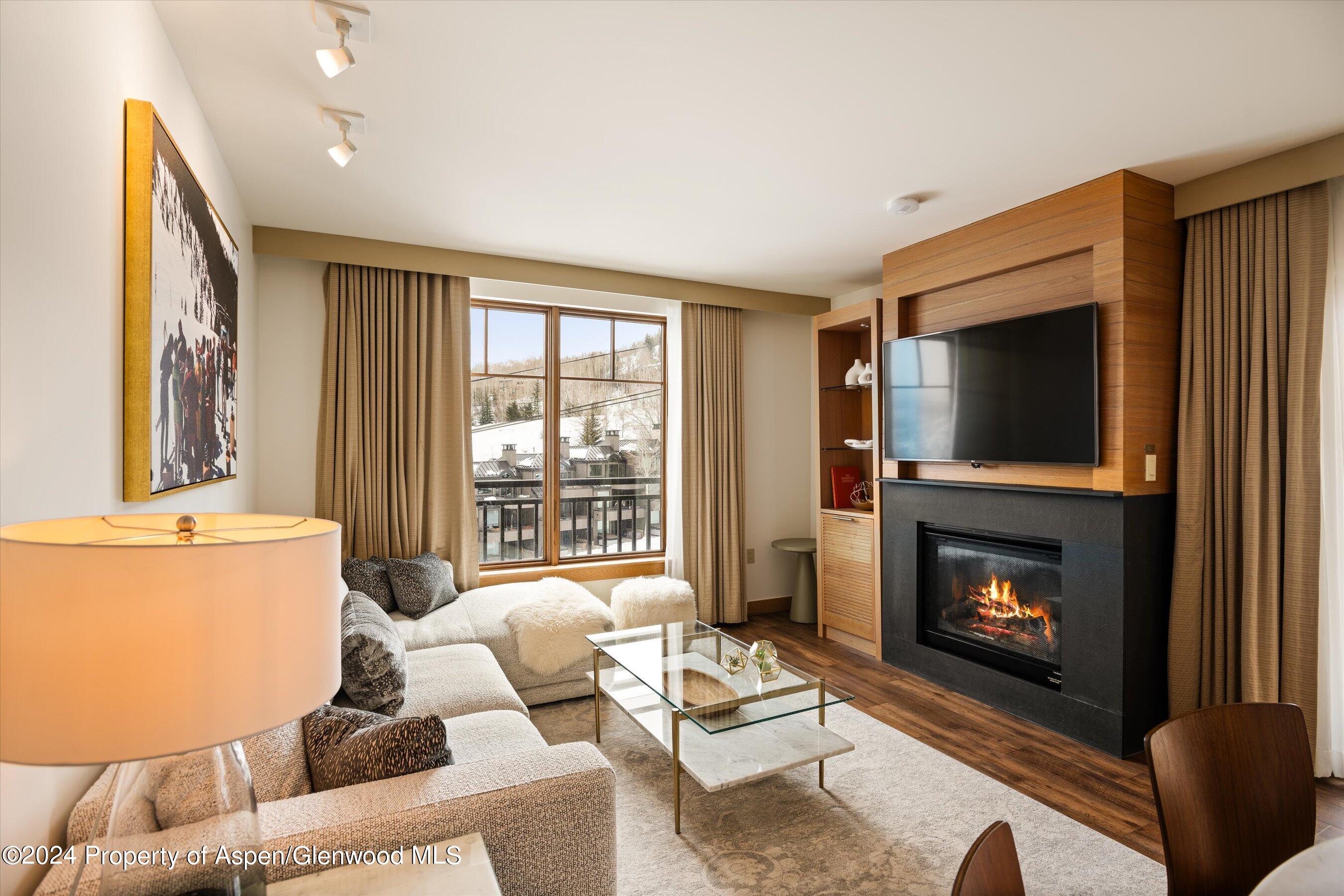 a living room with furniture a flat screen tv and a fireplace