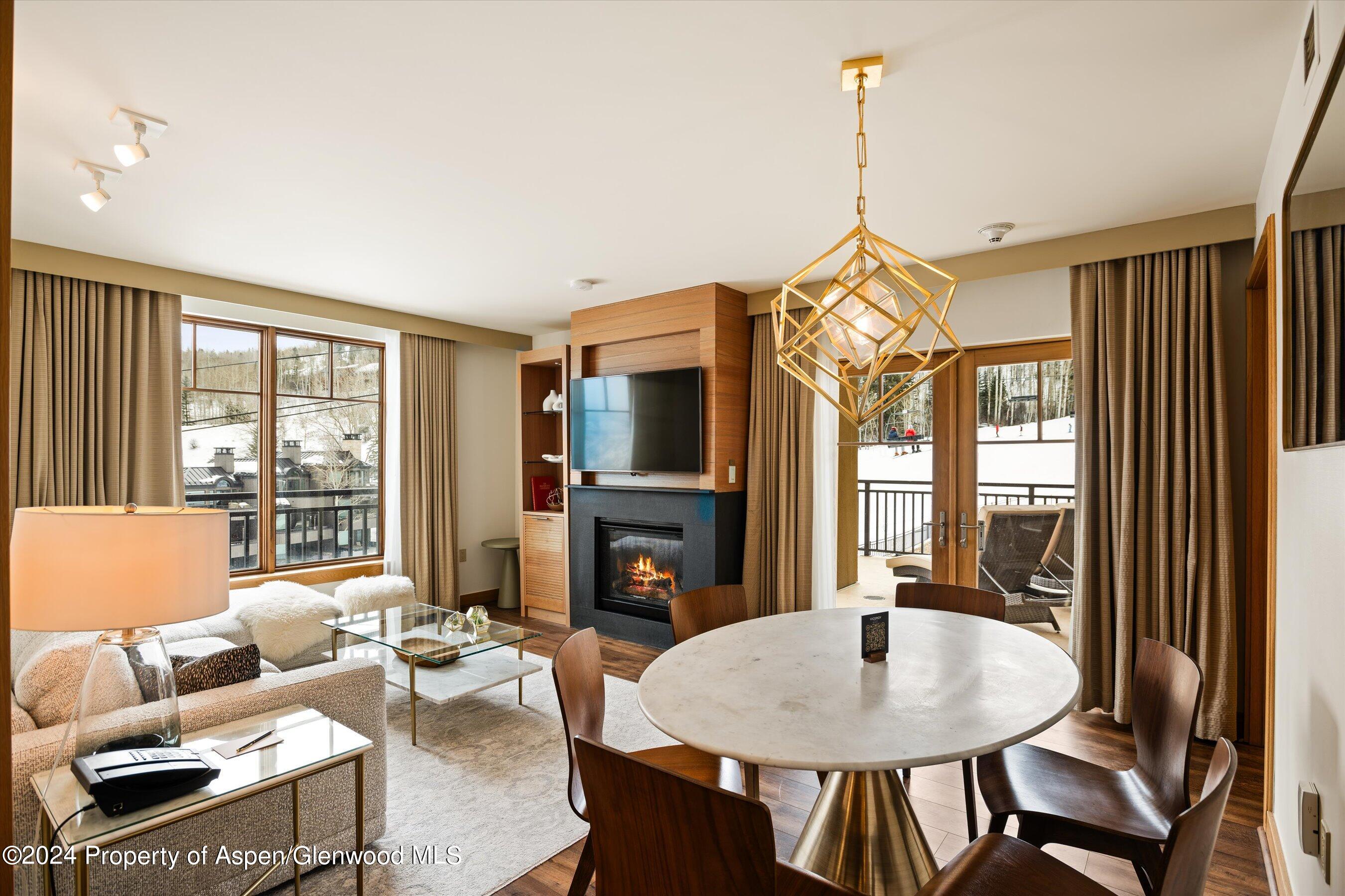 a living room with furniture a fireplace and a chandelier