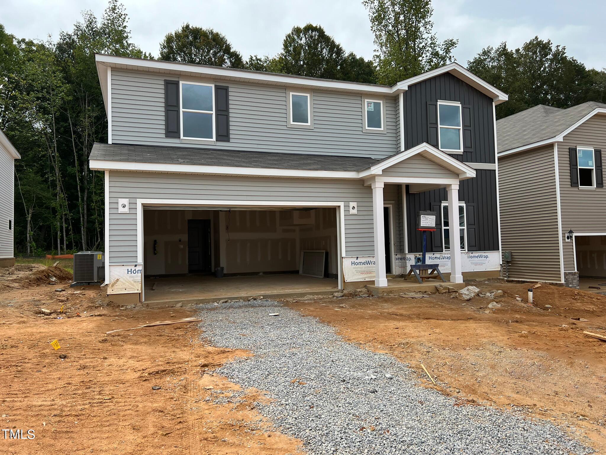 a front view of a house with yard and parking