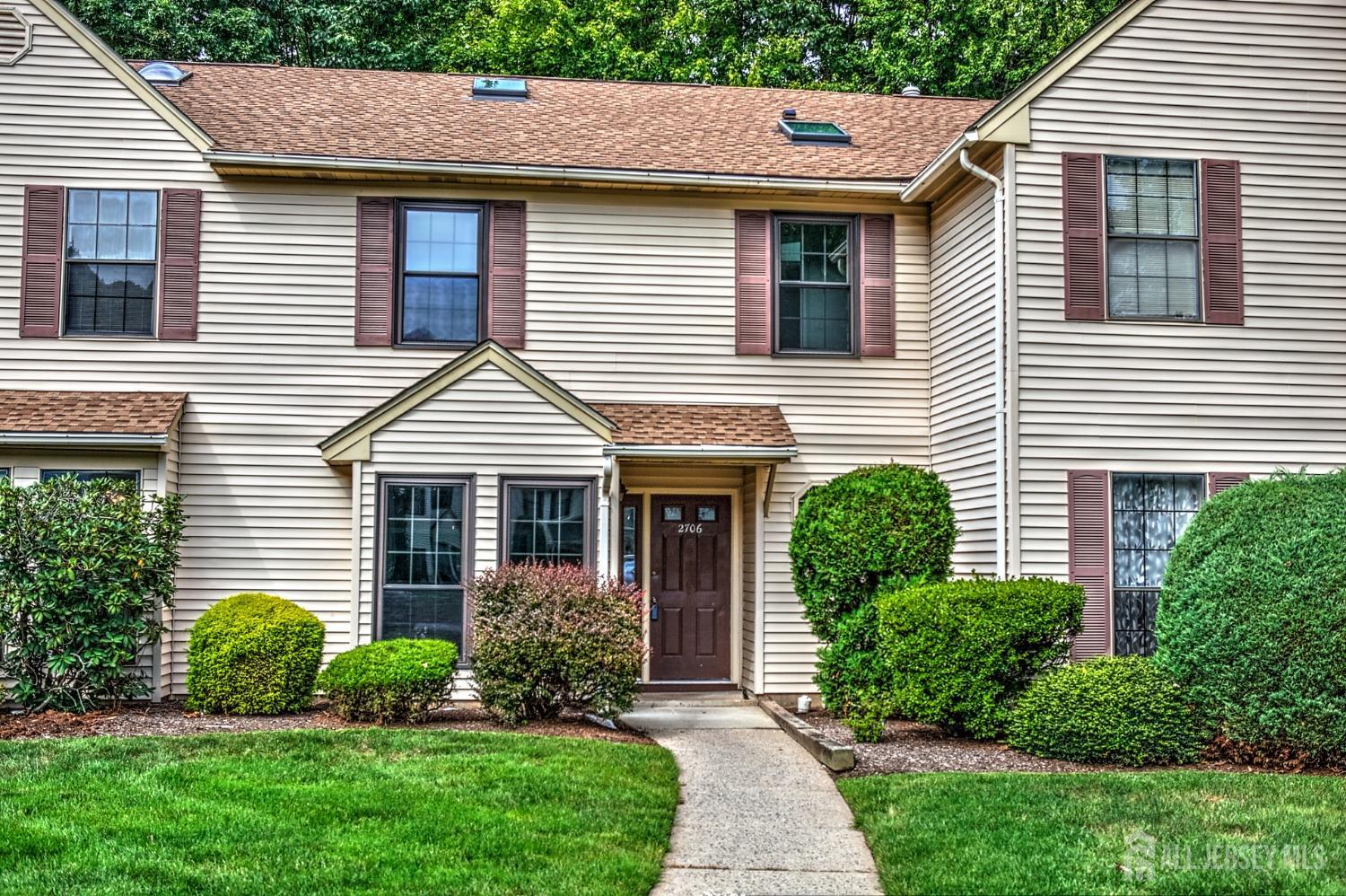 a front view of a house with a yard and plants