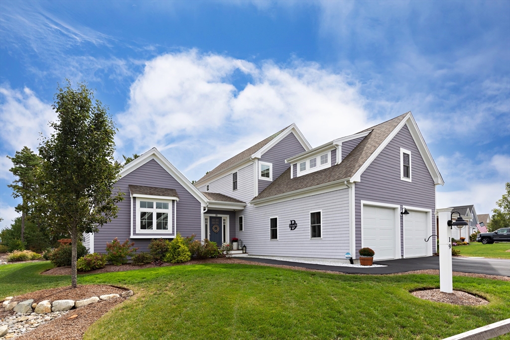 a front view of a house with a yard and trees