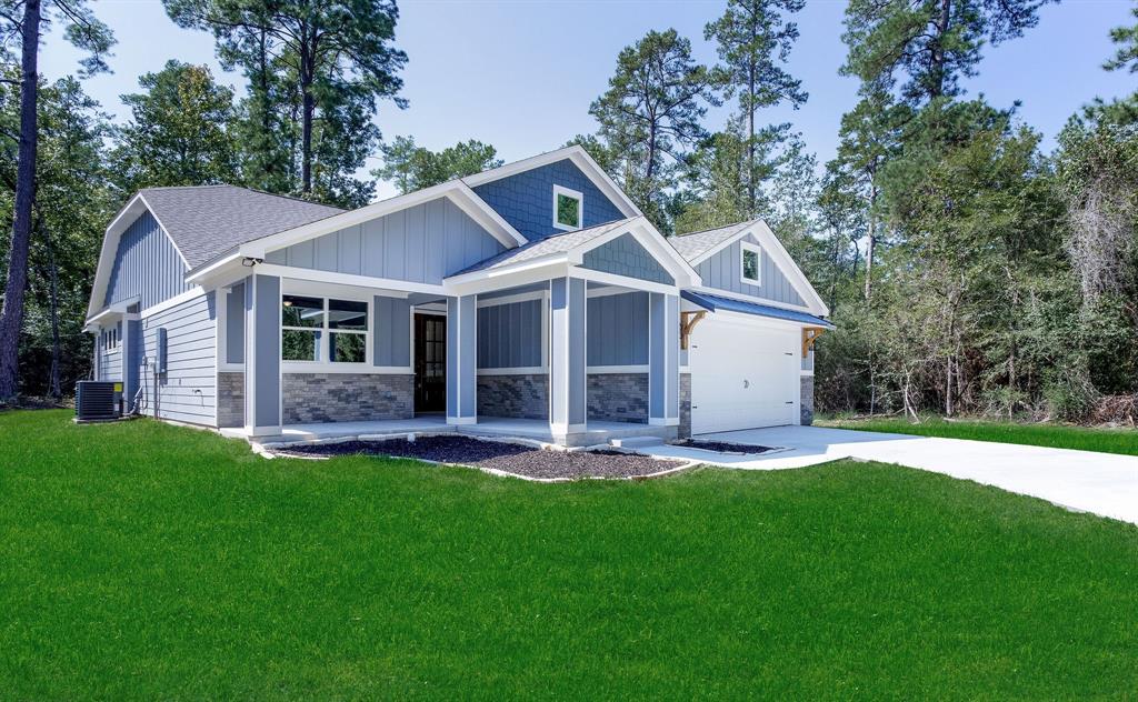 a front view of a house with a yard and large tree