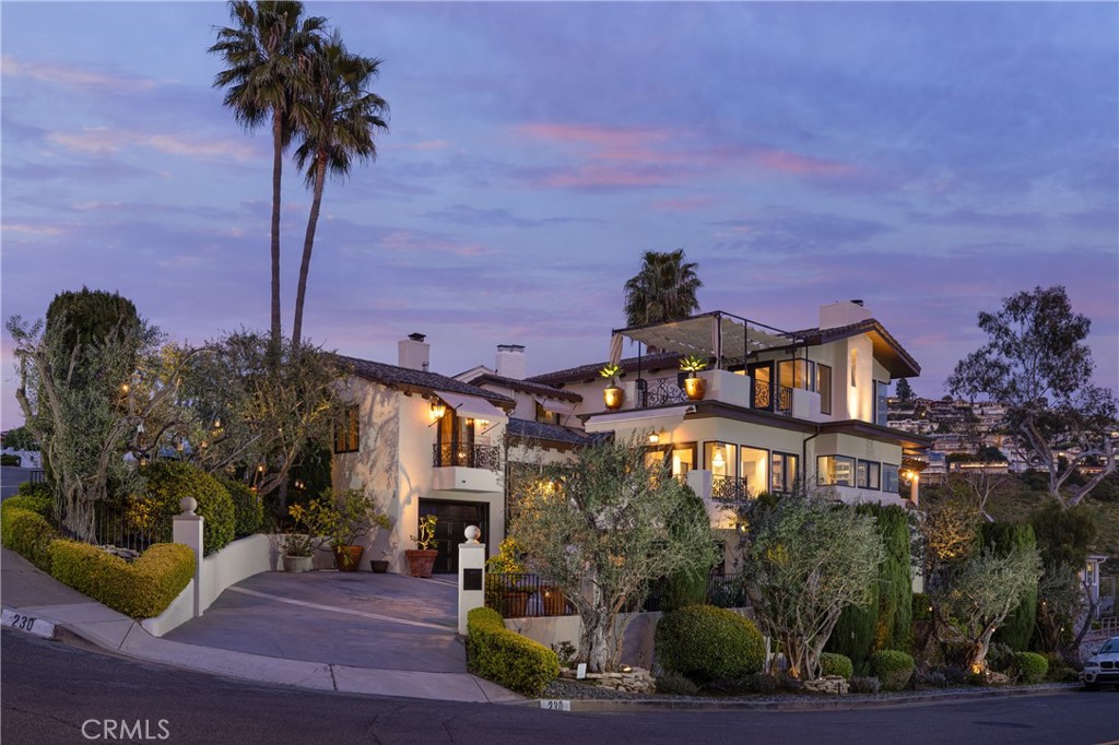 a front view of a house with a yard and potted plants