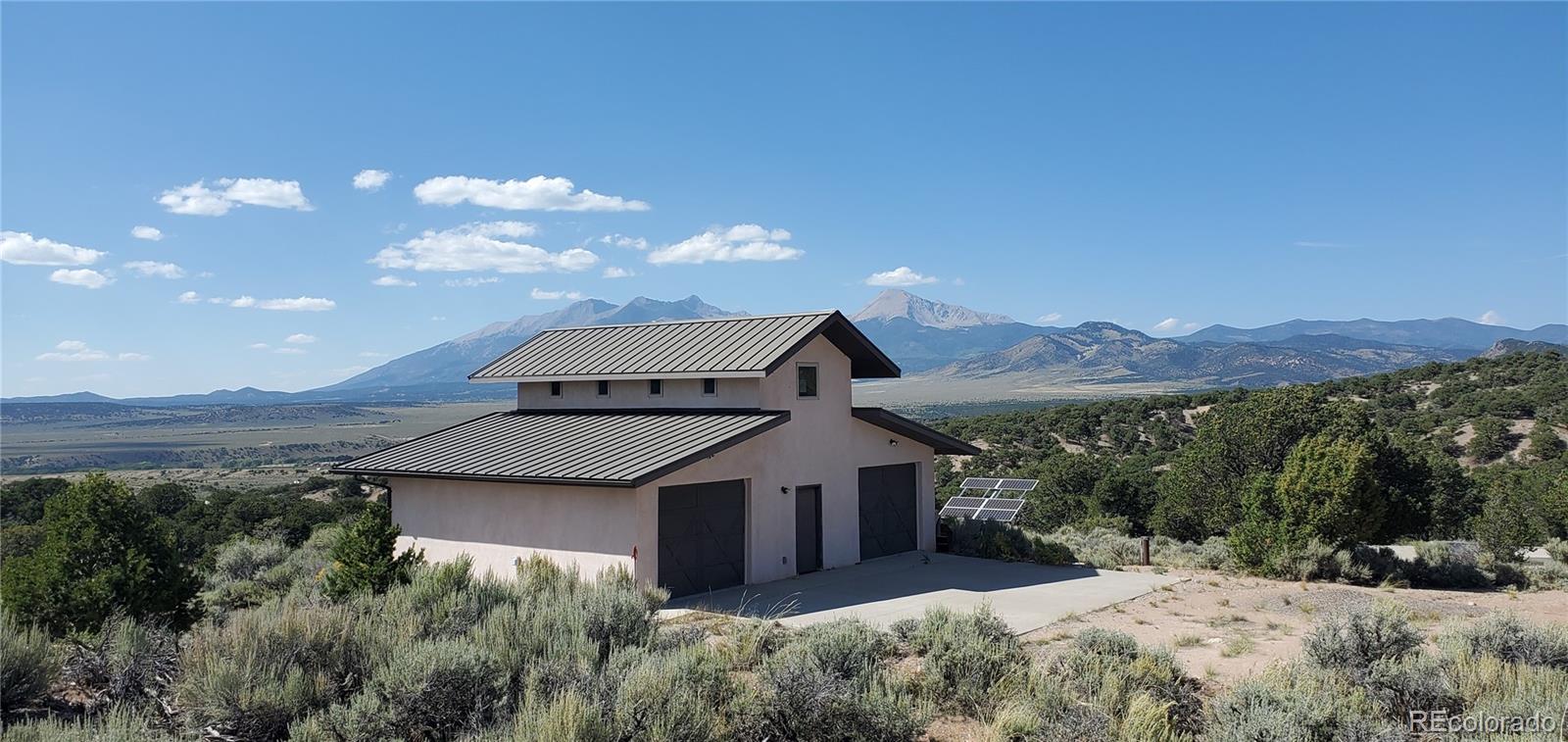 a front view of a house with a yard and mountain view in back