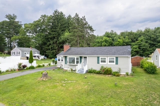 a front view of a house with a yard and trees