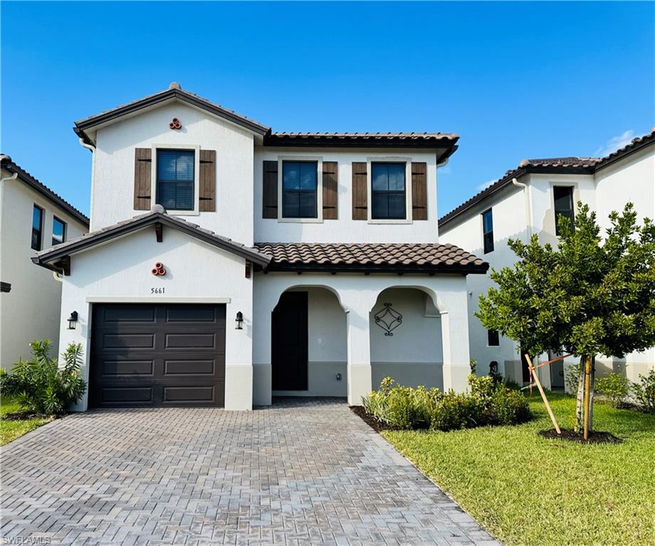 a front view of a house with a yard and garage