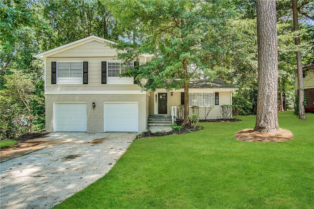 a front view of a house with a garden and yard