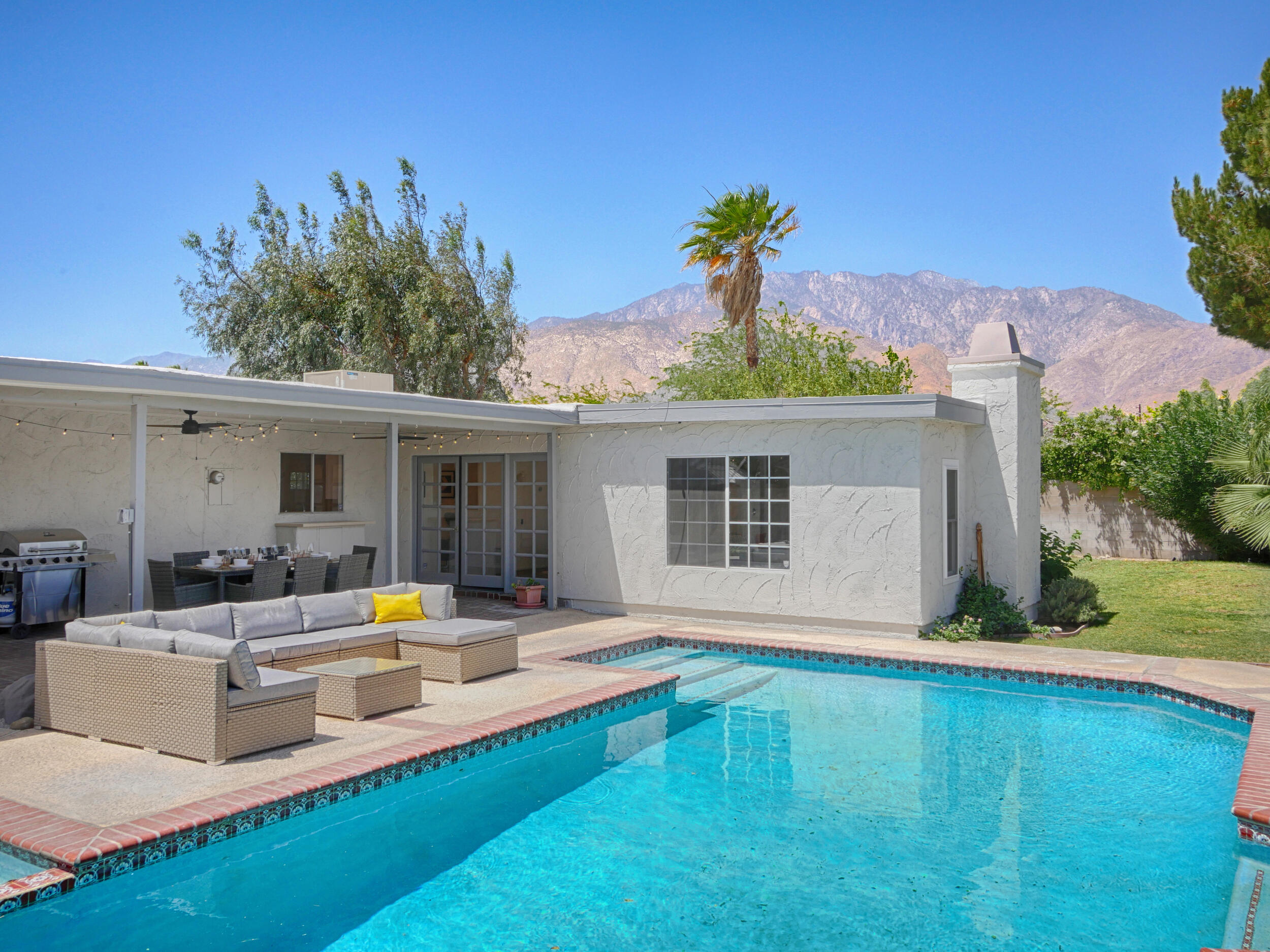 a view of a house with swimming pool and a yard