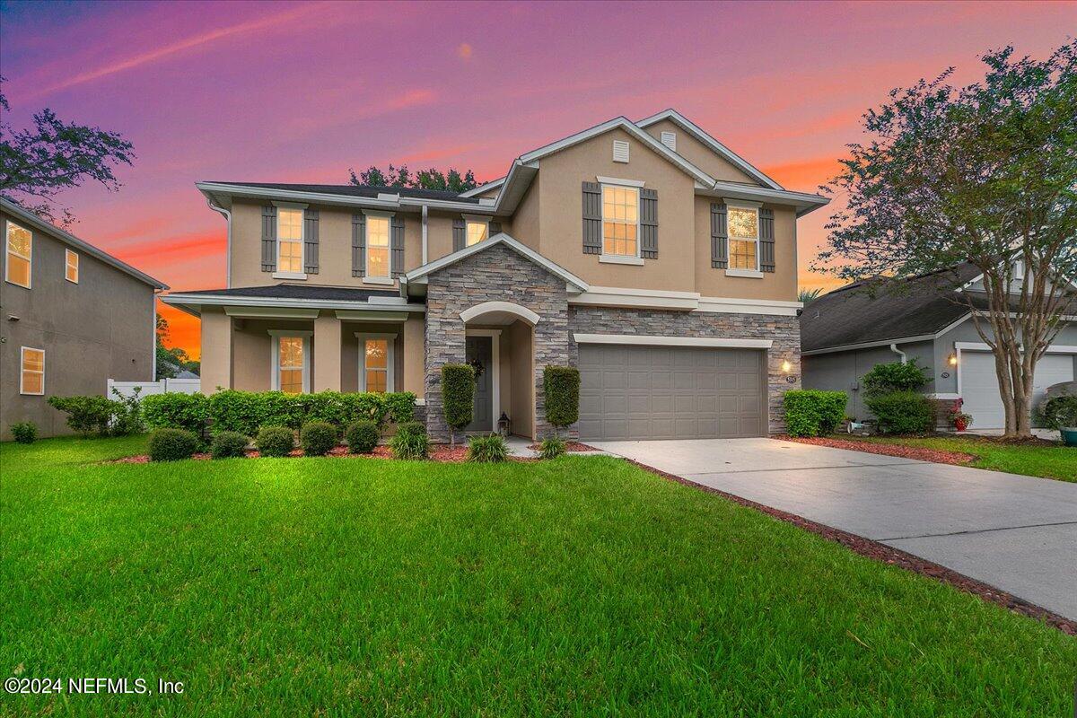 a front view of a house with a yard and garage