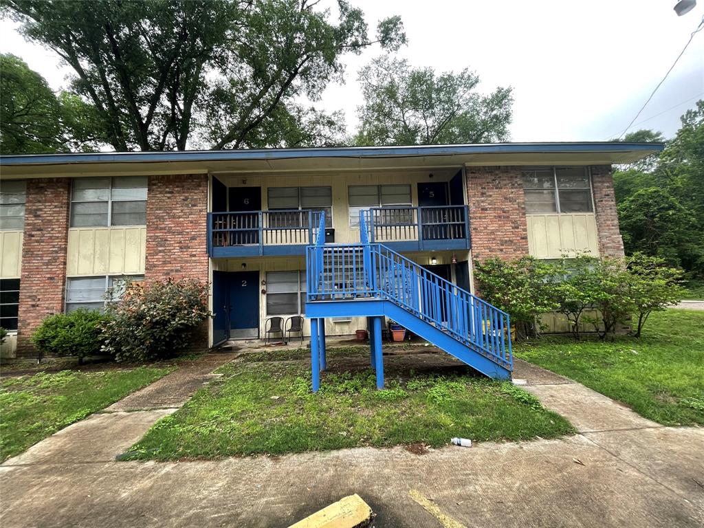 a view of house with a yard chairs and table in patio