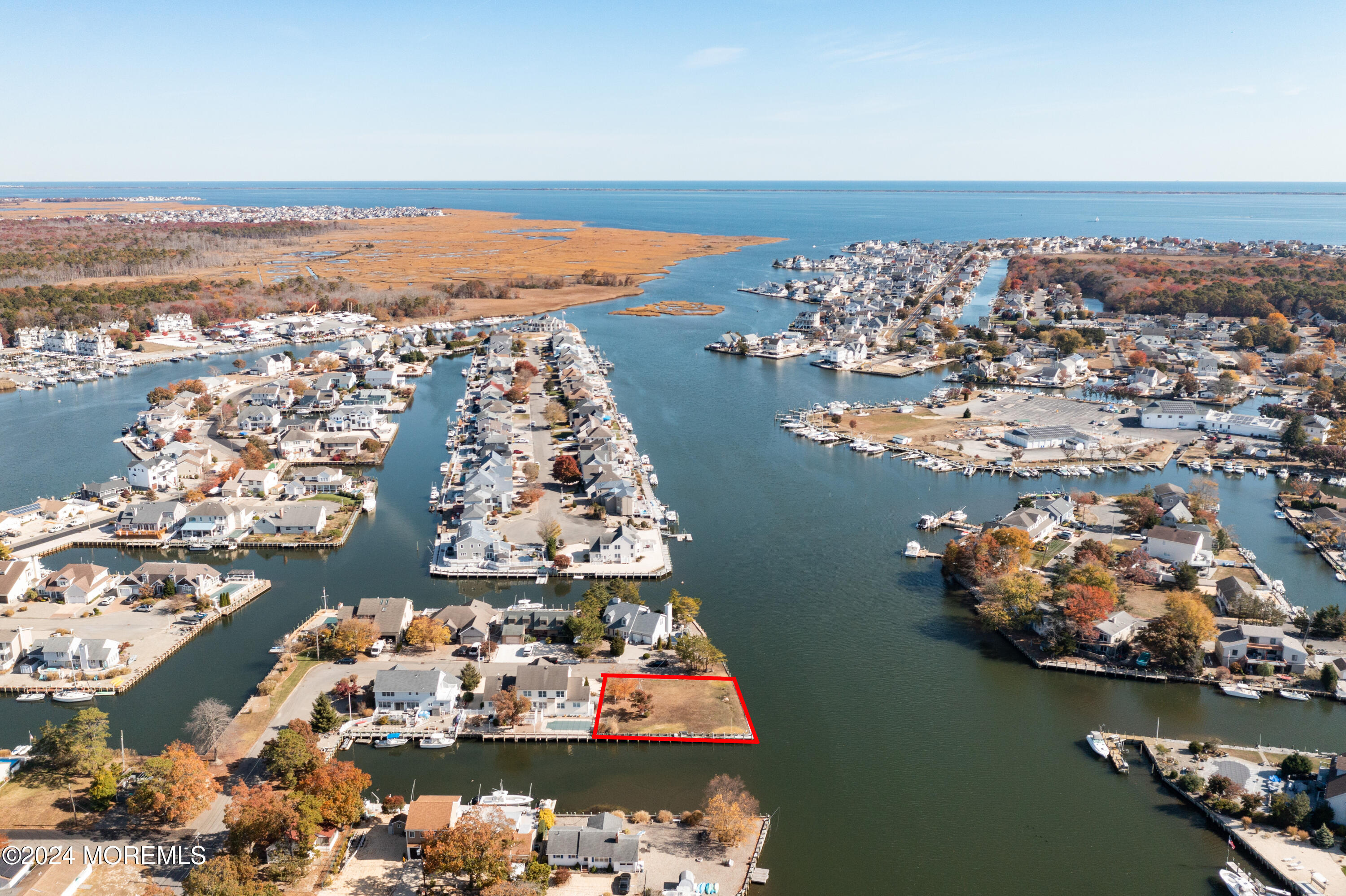 an aerial view of ocean and residential houses with outdoor space