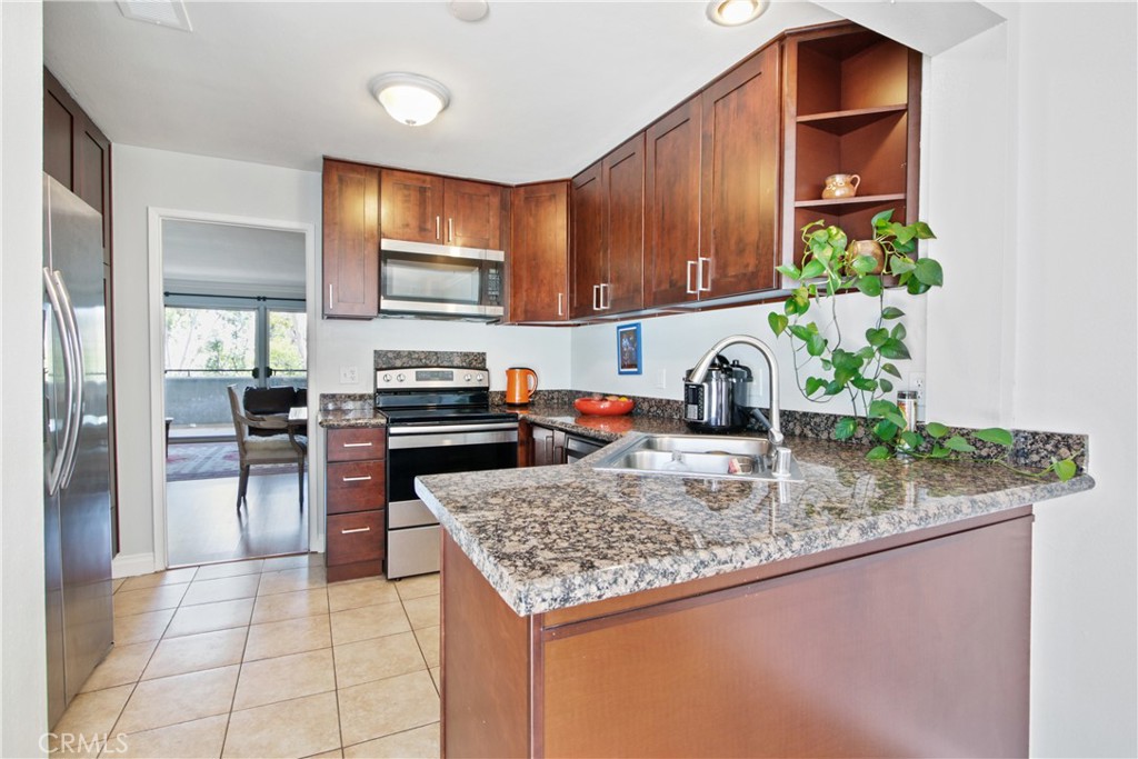 a kitchen with granite countertop a stove a sink and a microwave