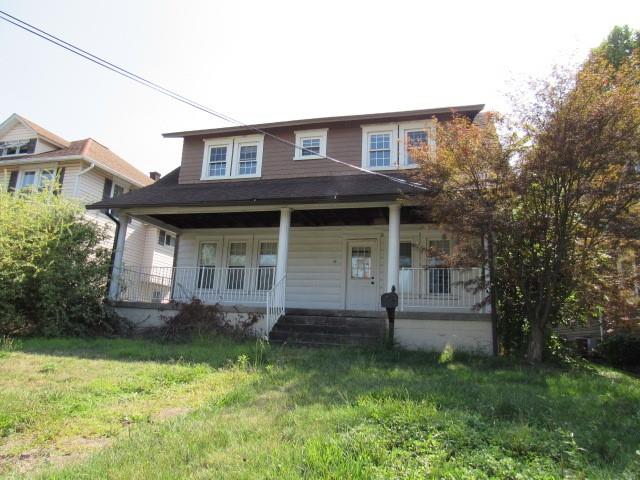 a view of a house with brick walls and a yard with plants