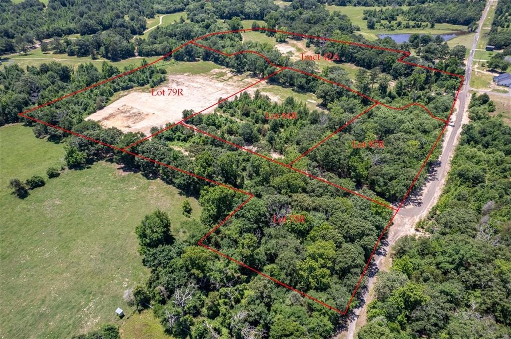 an aerial view of residential house with outdoor space and trees all around