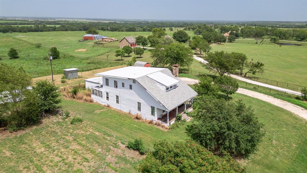 an aerial view of a house with a garden and lake view