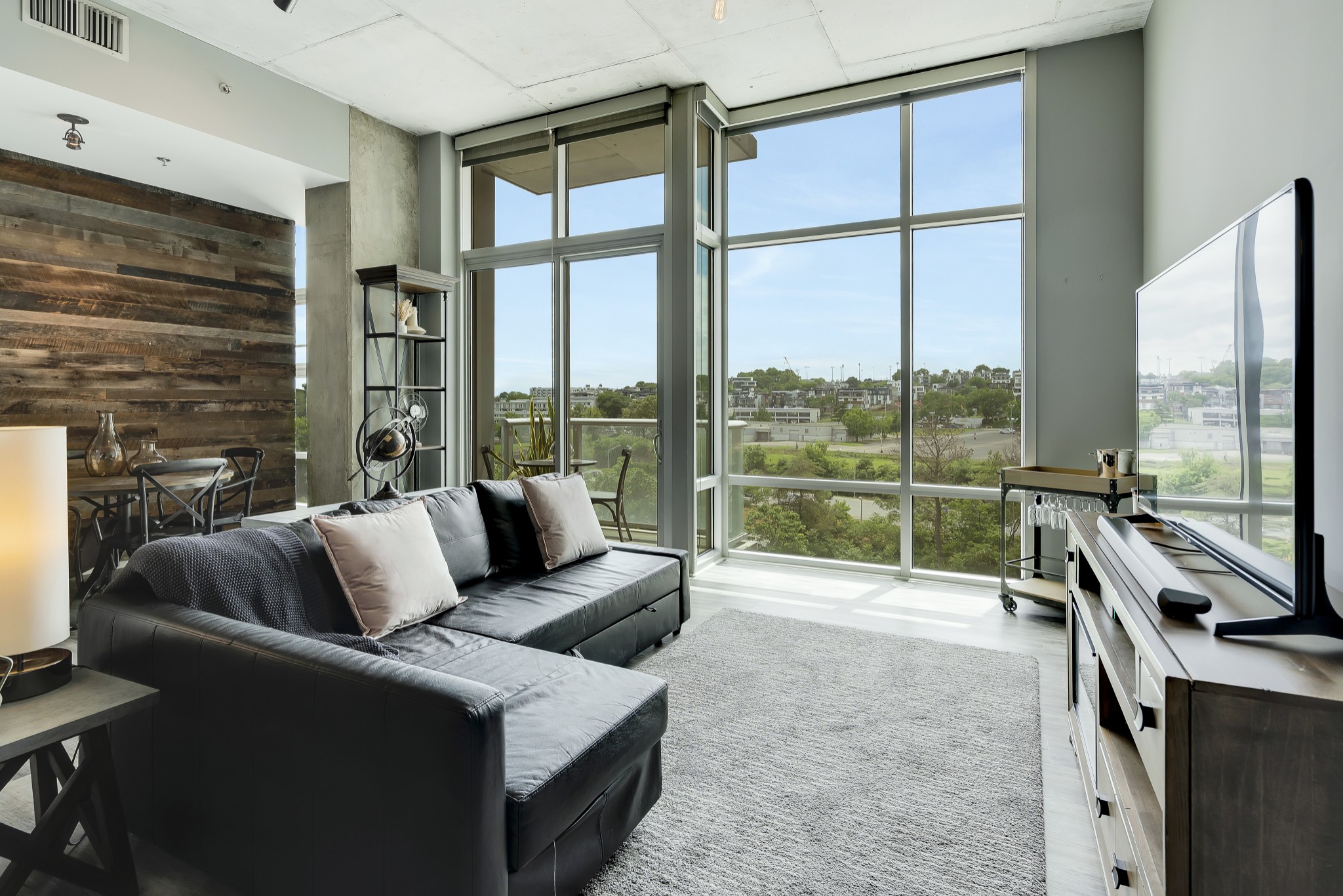 a living room with furniture and a floor to ceiling window