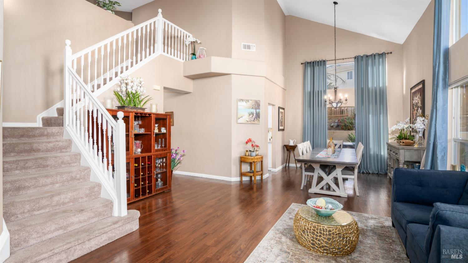 Enter to cathedral ceilings and wood floors in the formal living room and dining area