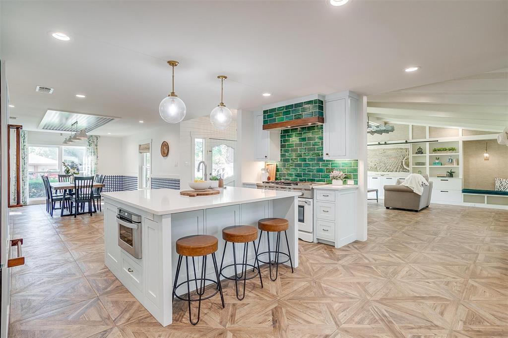 a kitchen with stainless steel appliances granite countertop a table and chairs in it