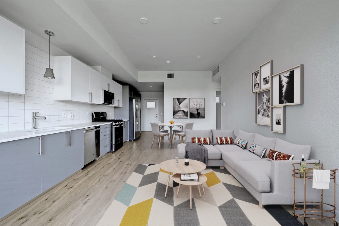 a living room with stainless steel appliances kitchen island granite countertop furniture and a kitchen view