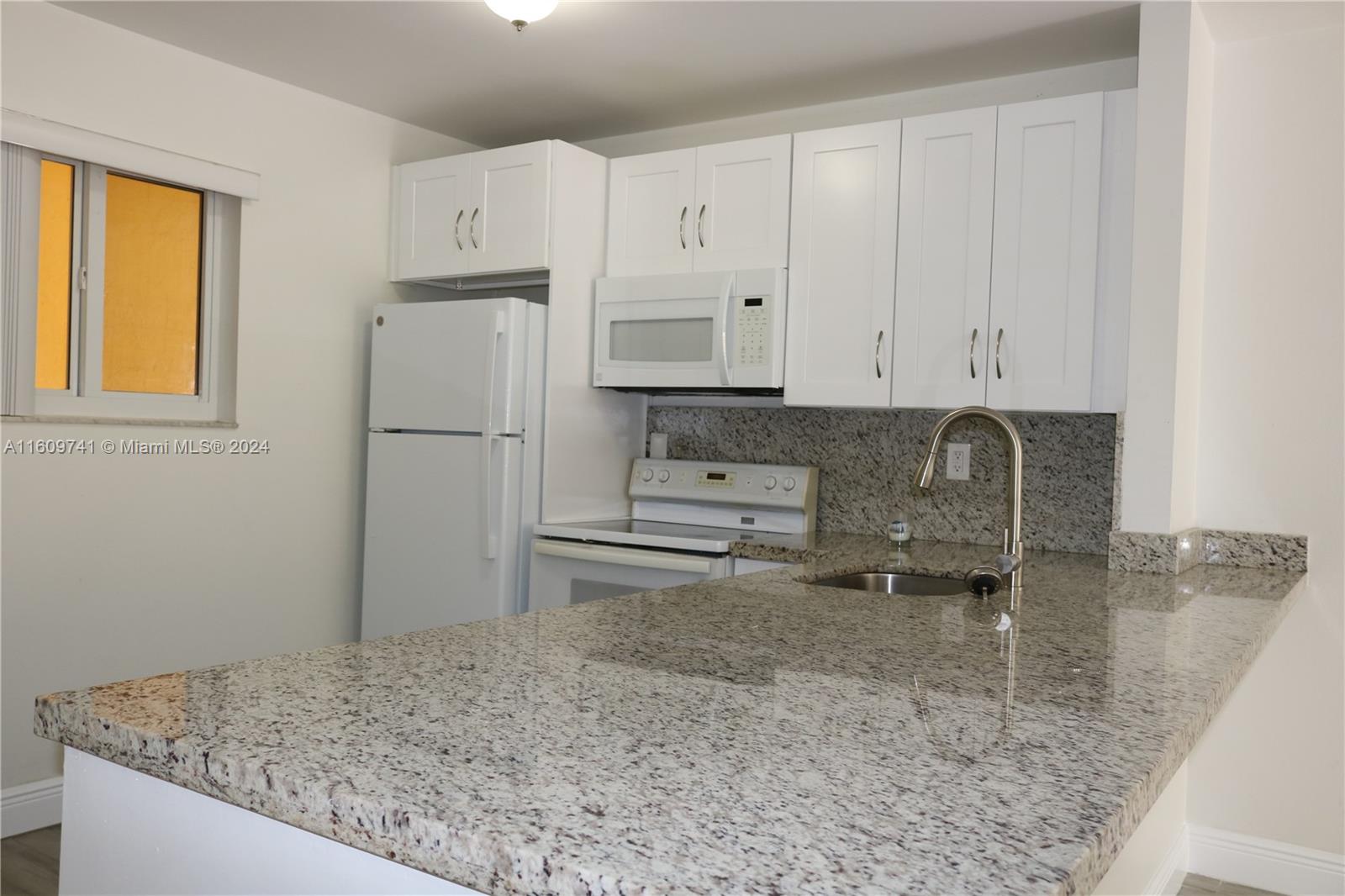 a kitchen with stainless steel appliances granite countertop a sink a stove and a refrigerator