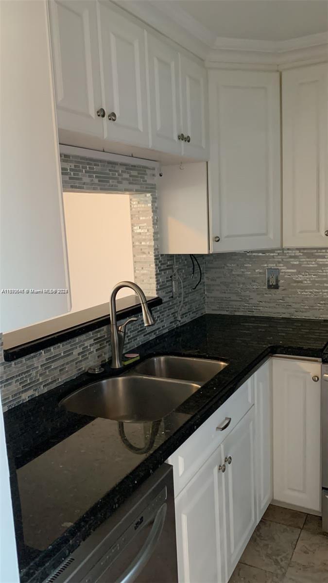 a kitchen with granite countertop a sink and cabinets