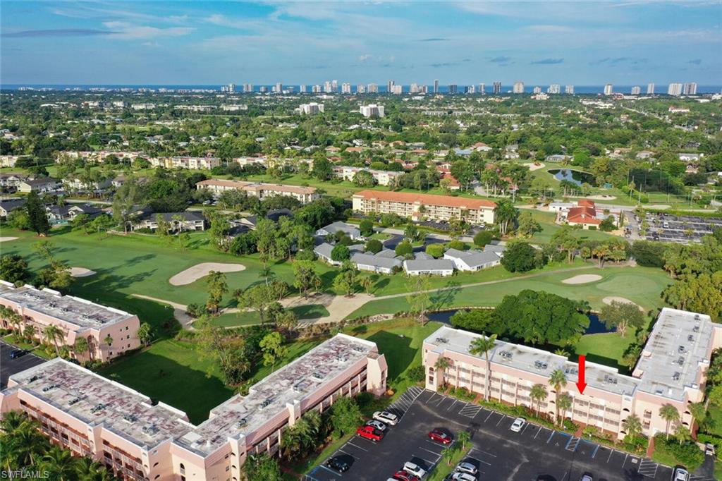 an aerial view of a city with lots of residential buildings ocean and mountain view in back