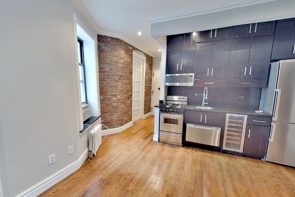 a kitchen with stainless steel appliances a refrigerator and wooden floor