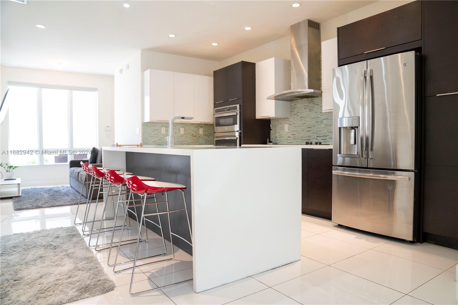 a kitchen with stainless steel appliances granite countertop a refrigerator and a stove