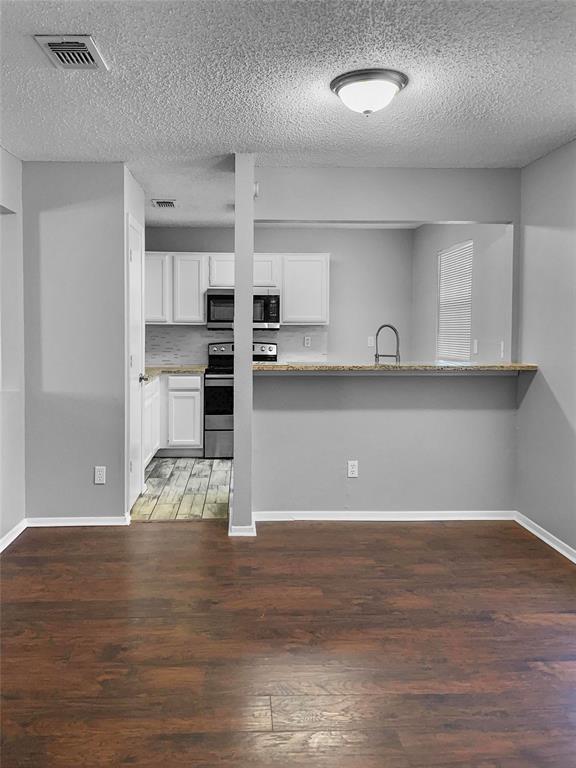 a view of a kitchen with wooden floor and cabinets