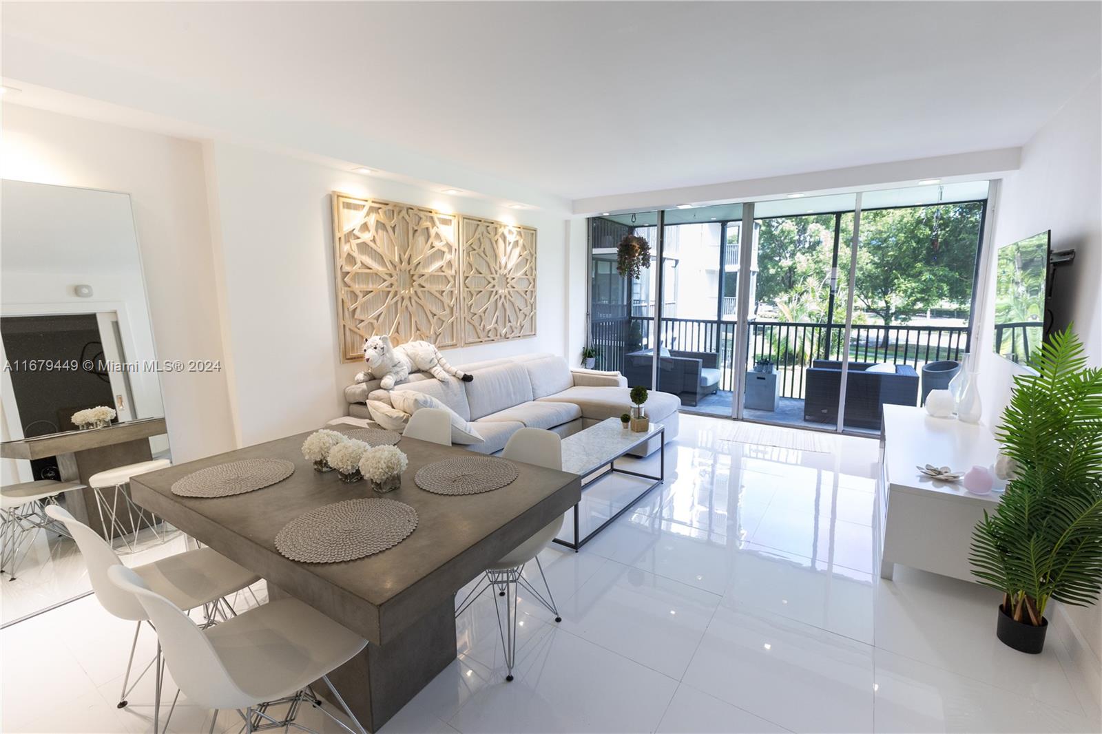 a living room with furniture a flat screen tv and a floor to ceiling window